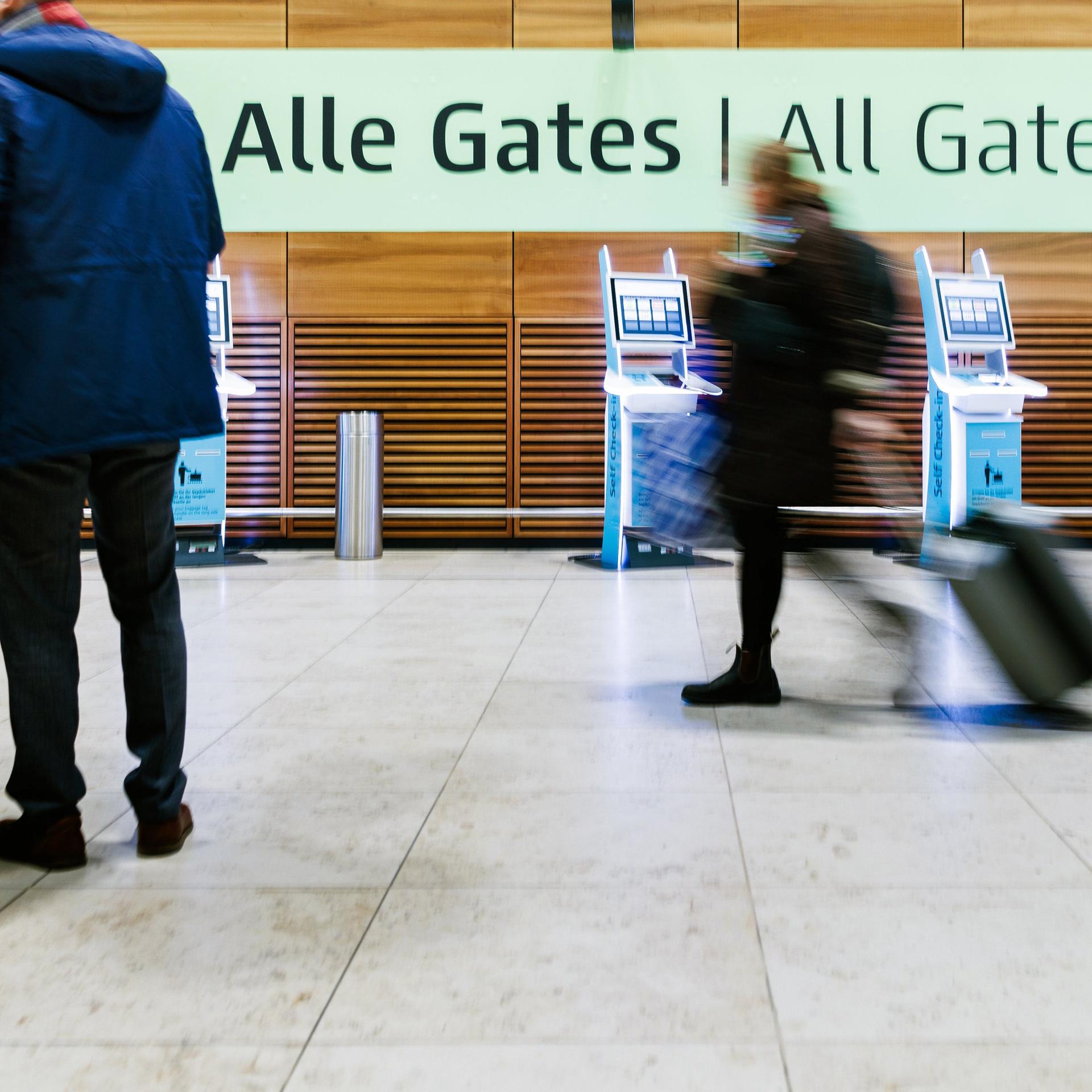 Berlin: Einige wenige Fluggäste ziehen Rollkoffer durch die Halle von Terminal 1 des Flughafens BER. 