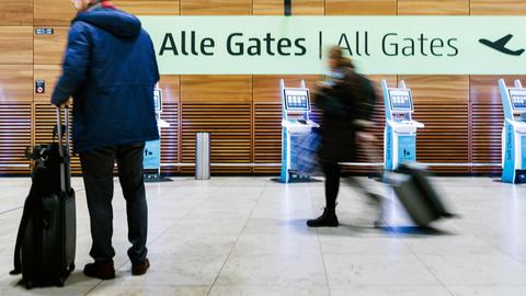 Berlin: Einige wenige Fluggäste ziehen Rollkoffer durch die Halle von Terminal 1 des Flughafens BER.