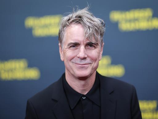 Porträt des lächelnden Schauspielers Jens Harzer auf dem roten Teppich vor der Eröffnung des 33. Filmfestes Hamburg 2025