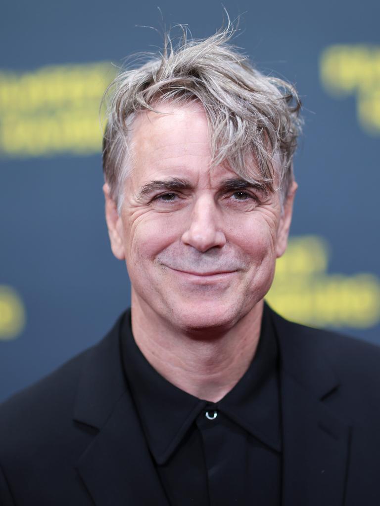 Porträt des lächelnden Schauspielers Jens Harzer auf dem roten Teppich vor der Eröffnung des 33. Filmfestes Hamburg 2025