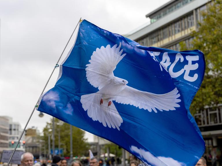 Fahne mit Friedenstaube bei der Demonstration "Die Waffen nieder" am Breitscheidplatz in Berlin. Die Veranstaltung richtet sich gegen jegliche Kriege und fordert den sofortigen Stopp aller Waffenlieferungen. Berlin, 03.10.2024