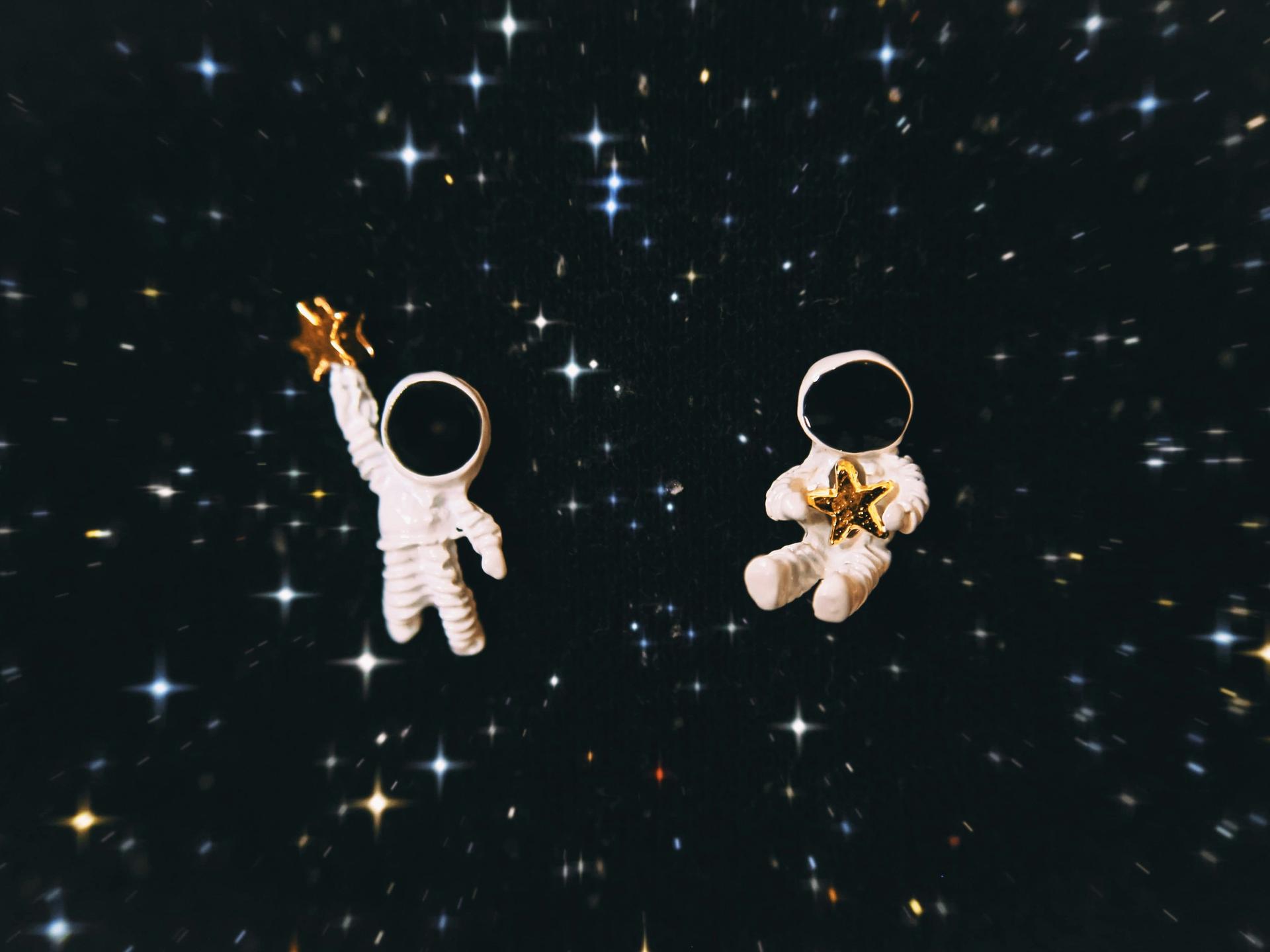 Zwei Astronauten mit je einem Stern in der Hand im Weltall. Zwei Astronauten mit je einem Stern in der Hand im Weltall.
