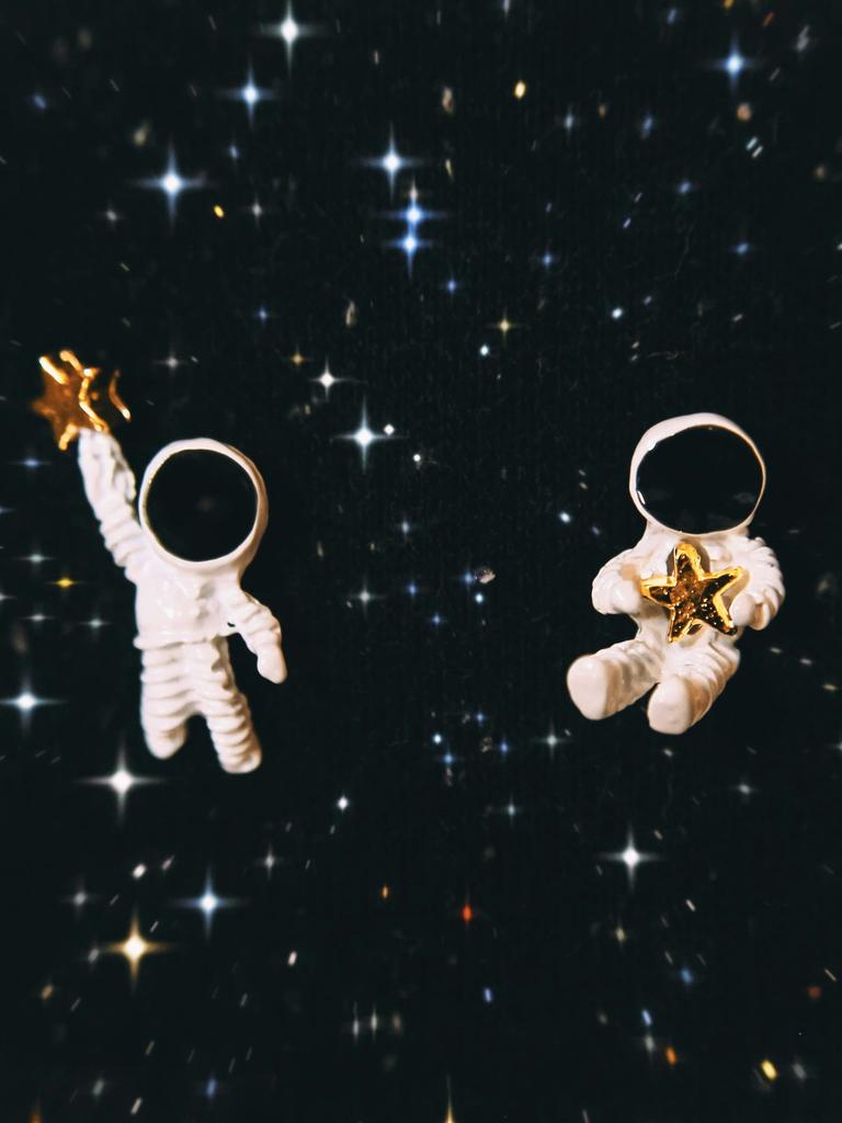 Zwei Astronauten mit je einem Stern in der Hand im Weltall. Zwei Astronauten mit je einem Stern in der Hand im Weltall.