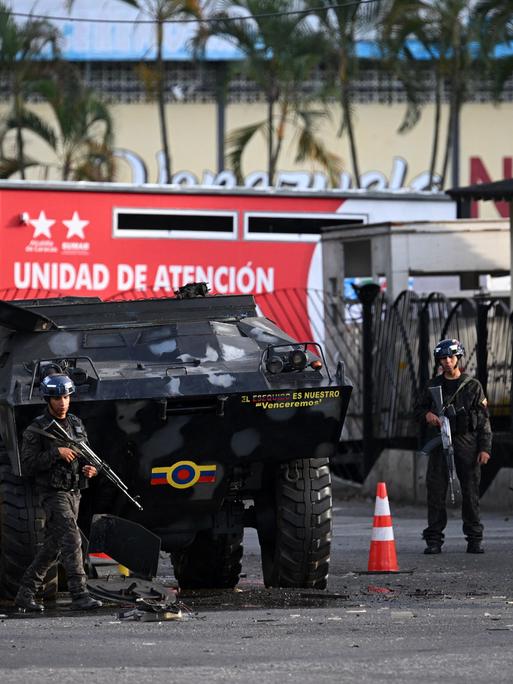 Mitglieder der Nationalgarde bewachen den Eingang von Fuerte Tiuna, Venezuelas größten Militärkomplex in Caracas. Zu sehen sind Personen in militärischer Uniform und ein Panzer.