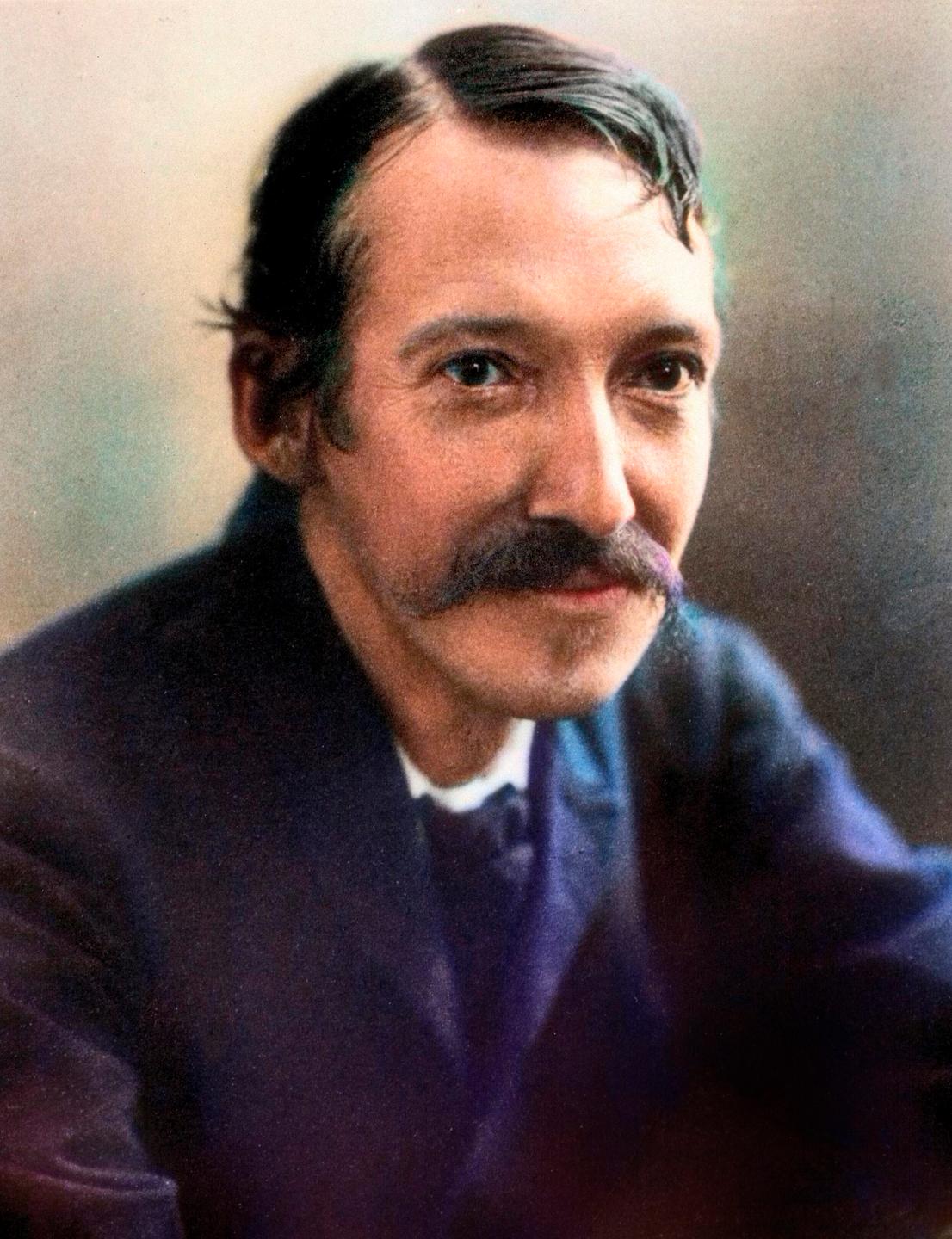 Ein lächelnder, schlanker Mann mit Schnurrbart.