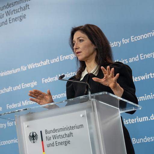 Die Bundesministerin für Wirtschaft und Energie, Katherina Reiche an einem Rednerpult vor einer blauen, weiß beschrifteten Wand 