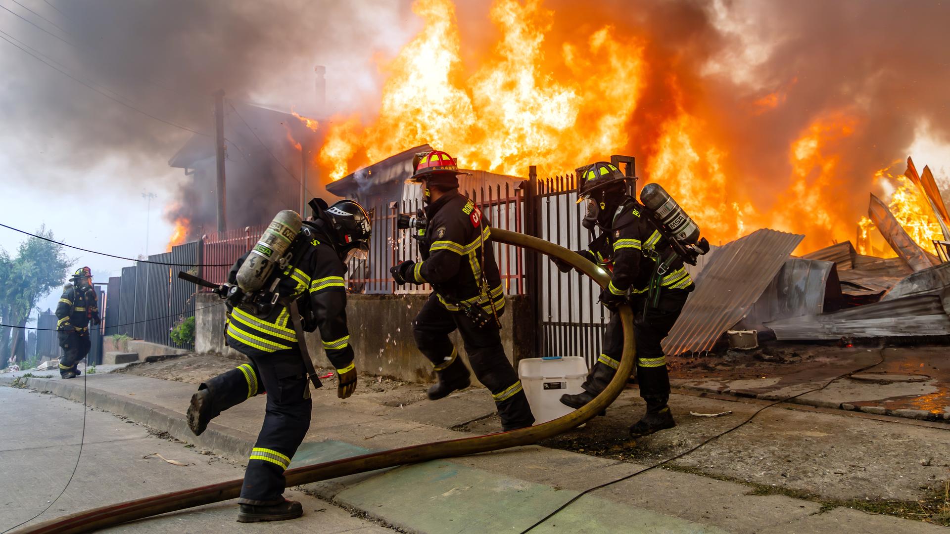 Feuerwehrleute bekämpfen einen Brand in einem Haus. 