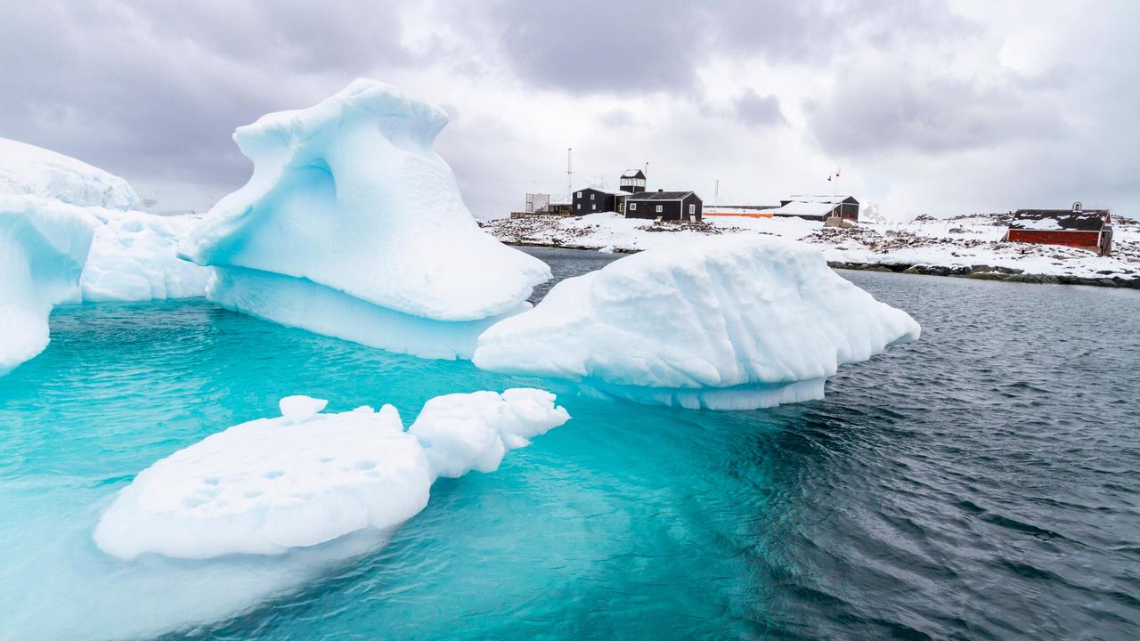 Die chilenische González-Videla-Antarktis-Station in der Paradise Bay, Antarktis, 2024. Im Vordergrund Eisschollen vor einer Ansammlung von Häusern.