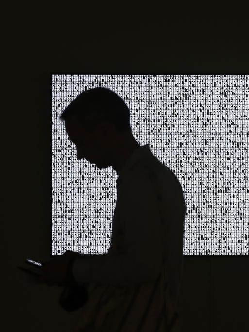 Ein Besucher läuft an einem Ausstellungstück in New York vorbei, das auf einem Bildschirm gezeigt wird. Es handelt sich um eine Ausstellung des Auktionshauses Sotheby's.