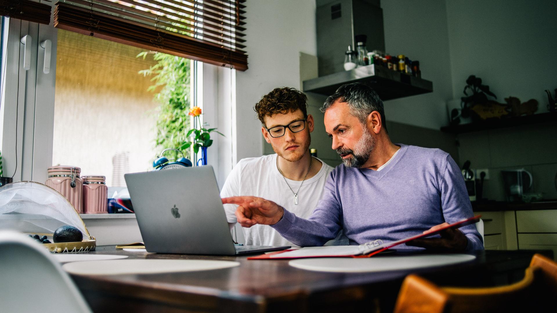 Ein Vater sitzt mit seinem Sohn an einem Laptop (gestellte Szene). Foto: Zacharie Scheurer || Modellfreigabe vorhanden