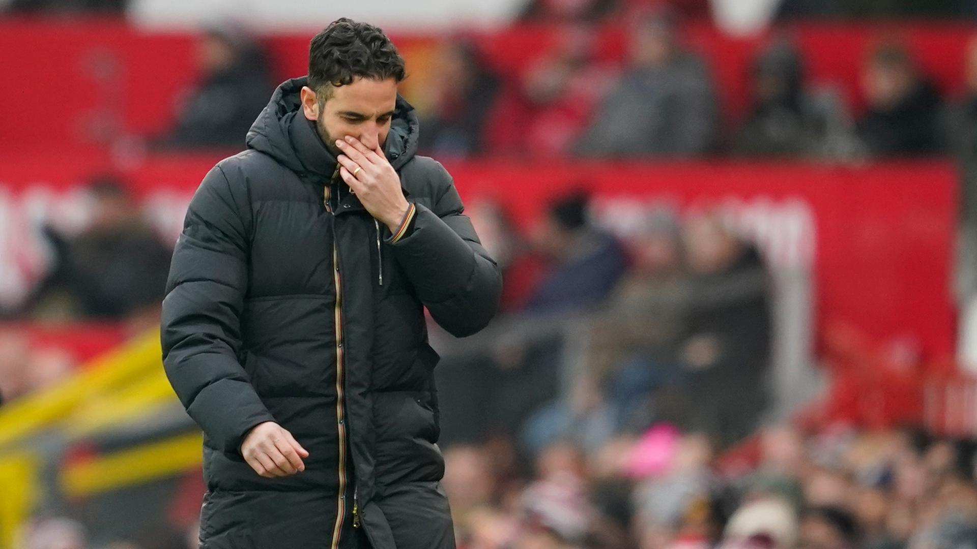 Amorim in einem schwarzen Wintermantel mit gesenktem Kopf am Spielfeldrand im Stadion, dahinter unscharf eine Tribüne mit Zuschauern.