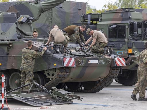 Eine Panzerhaubitze 2000 der Bundeswehr wird instand gesetzt, mehrere Soldaten arbeiten mit Werkzeug auf dem Panzer, 2022.