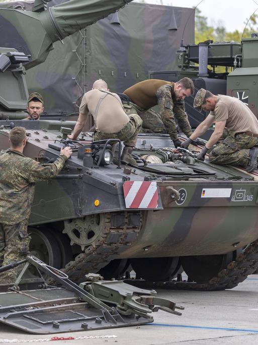 Eine Panzerhaubitze 2000 der Bundeswehr wird instand gesetzt, mehrere Soldaten arbeiten mit Werkzeug auf dem Panzer, 2022.