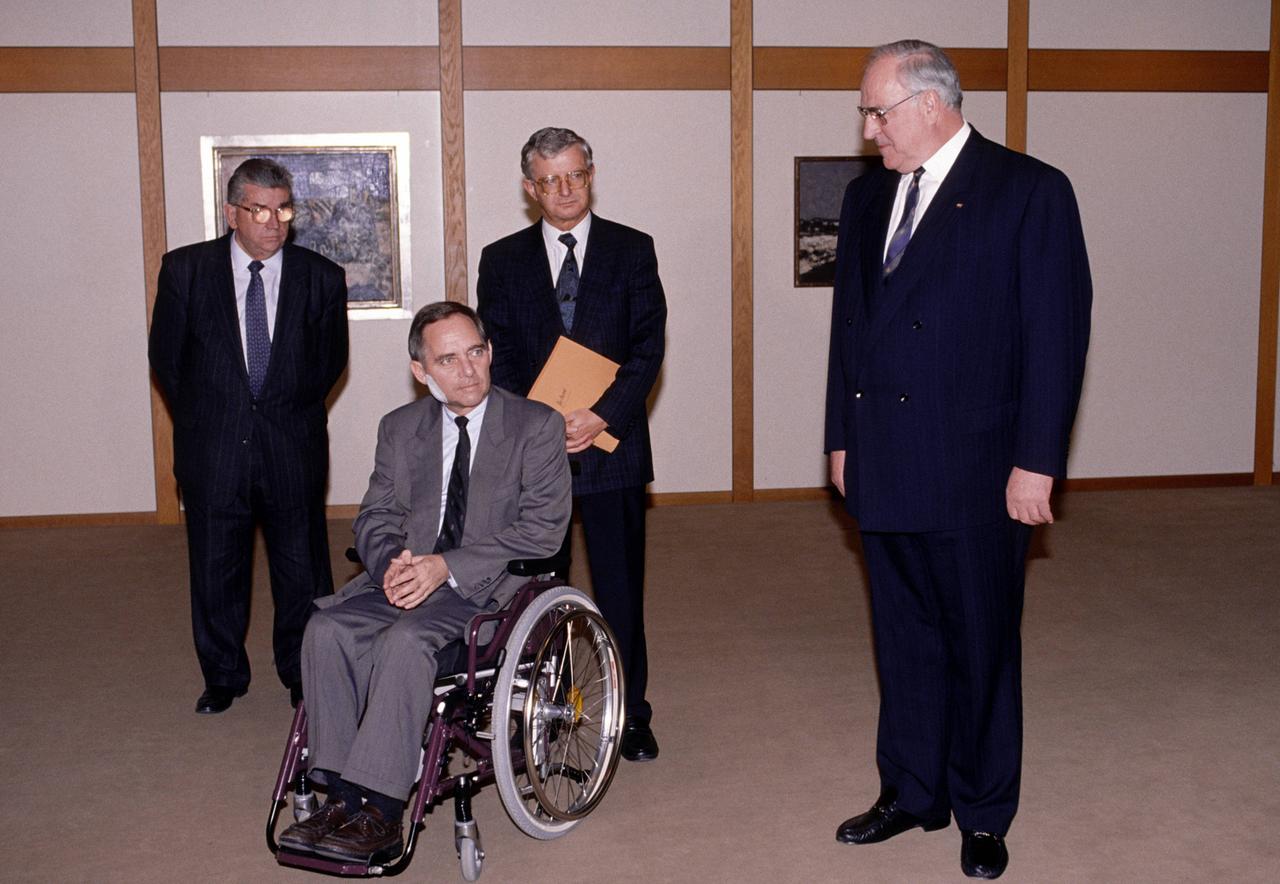 Wolfgang Schäuble fährt nach dem Attentat im November 1990 zum ersten Mal im Rollstuhl zur Kabinettsitzung und wird vom damaligen Bundeskanzler Helmut Kohl begruesst.