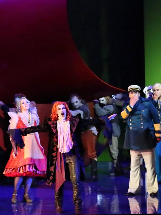 Die Solisten und der Chor der "Holländer"-Inszenierung stehen in bunten Kostümen auf der Bühne der Komischen Oper