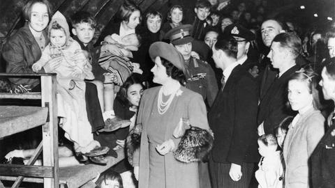 King George VI. und Queen Elizabeth besuchen 1940 in den U-Bahn-Schächten Zivilisten, die vor dem deutschen Bomberangriff auf London dort Schutz suchen.