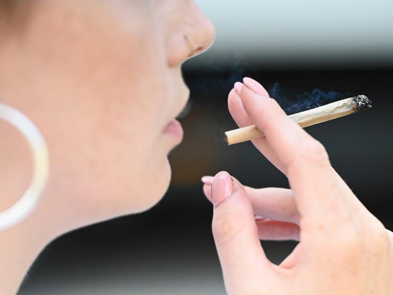 Eine Frau raucht einen Joint.