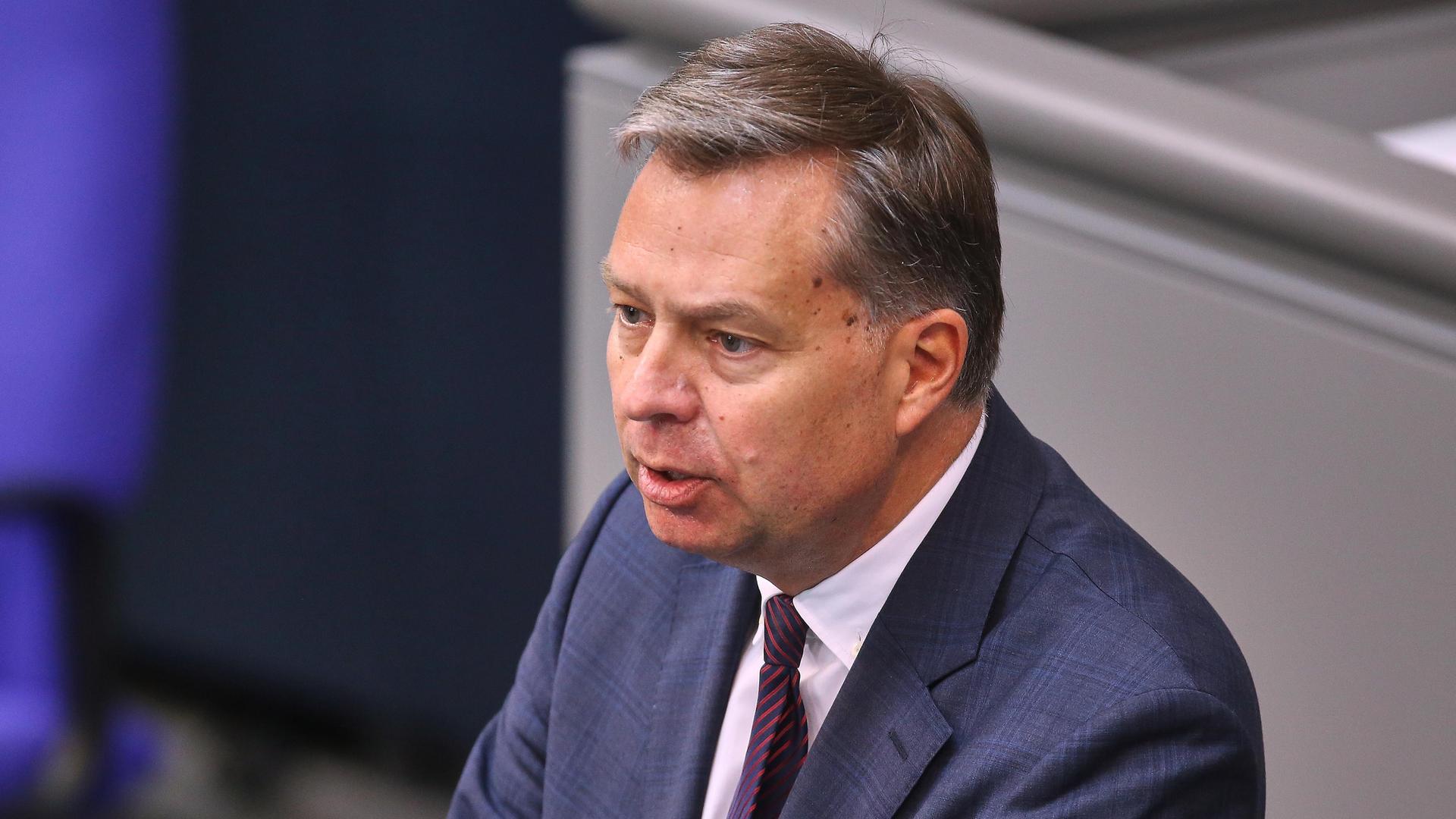 Mayer im dunklen Jackett mit Krawatte spricht am Rednerpult im Bundestag. Mayer im dunklen Jackett mit Krawatte spricht am Rednerpult im Bundestag.