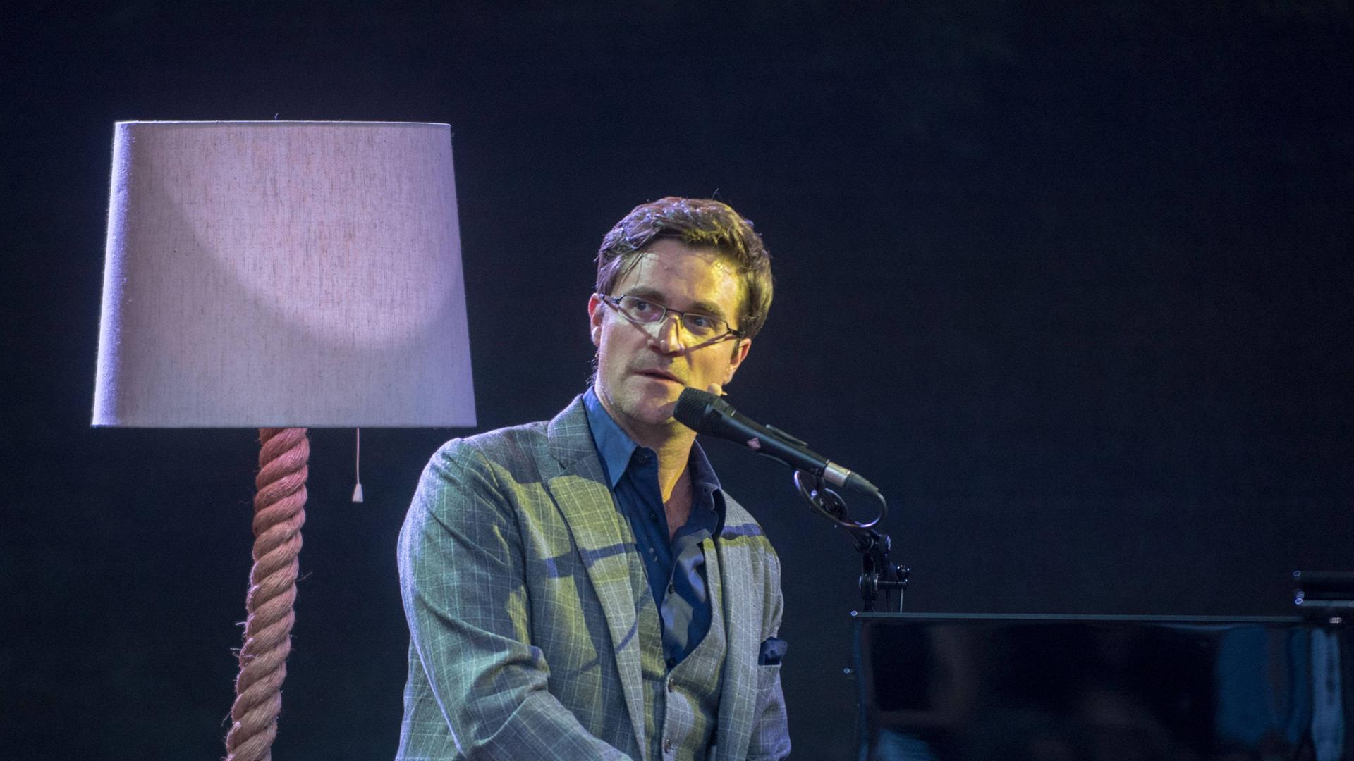 Der Musikkabarettist Bodo Wartke sitzt am Klavier und singt in ein Mikrofon. Der Musikkabarettist Bodo Wartke sitzt am Klavier und singt in ein Mikrofon.