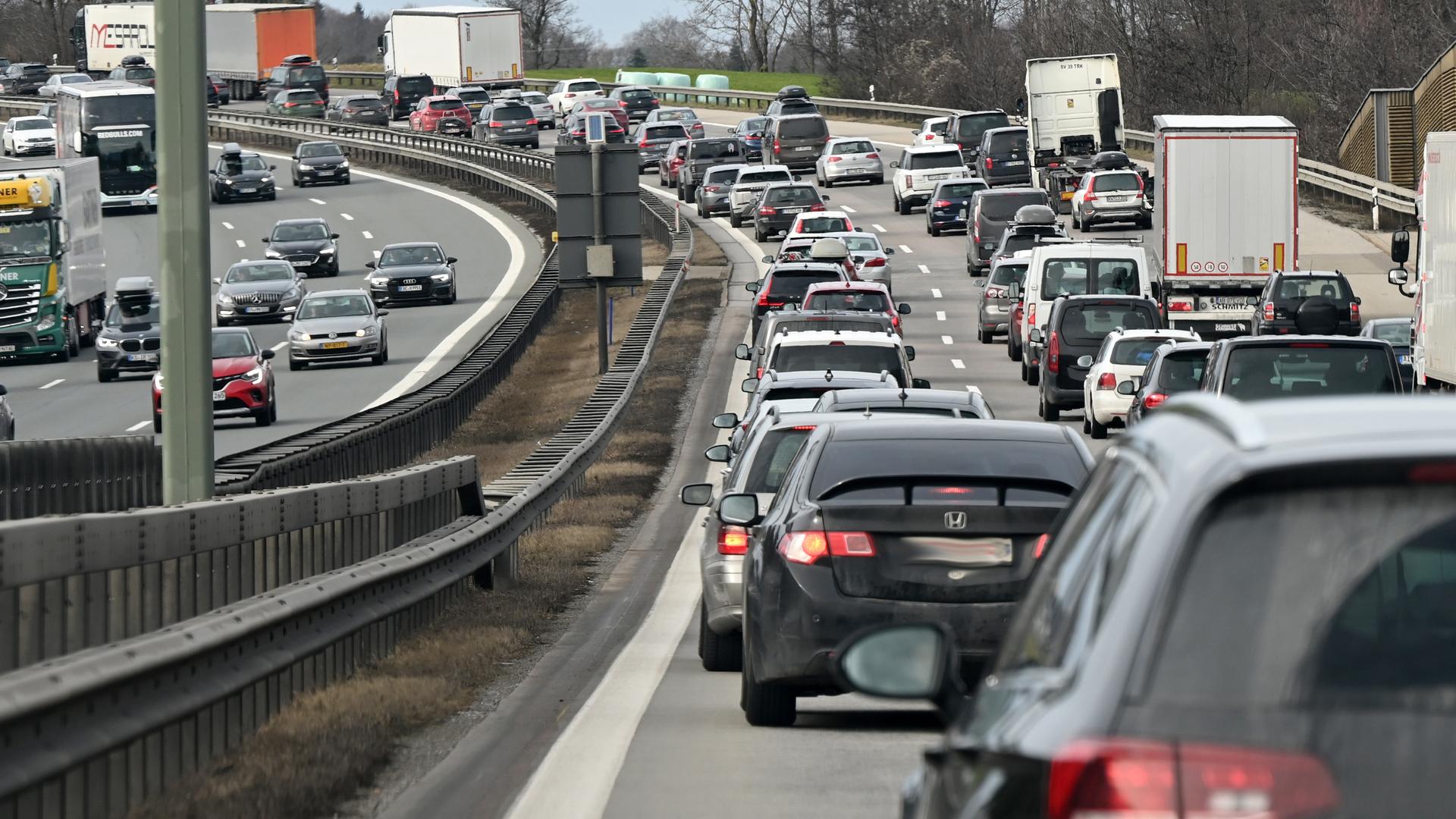 Auf einer großen Autobahn fahren sehr viele LKW und Autos. In eine Richtung gibt es einen Stau. Auf einer großen Autobahn fahren sehr viele LKW und Autos. In eine Richtung gibt es einen Stau.