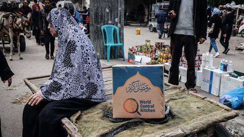 Eine Frau in Rafah im Gazastreifen sitzt neben einer Kiste mit Lebensmitteln der Hilfsorganisation World Central Kitchen
