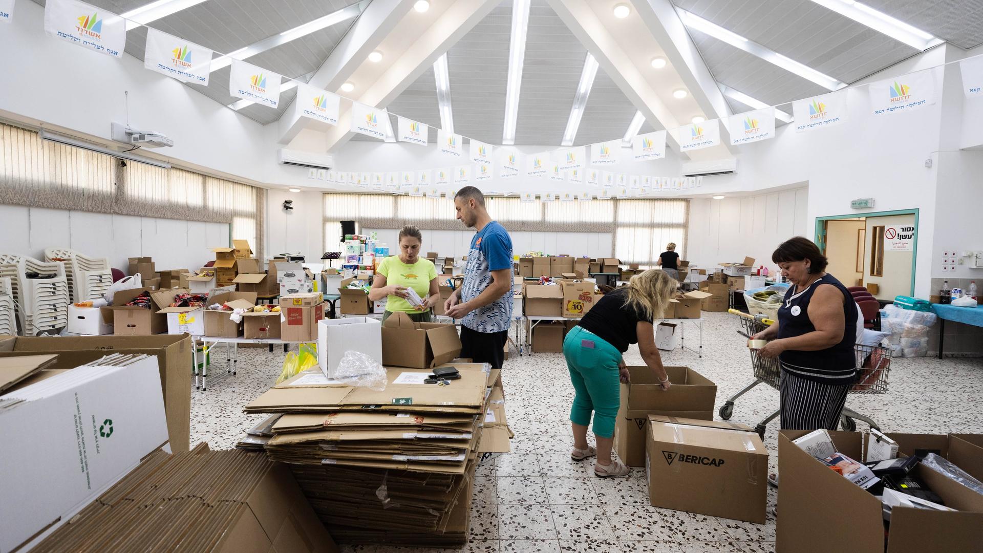 Im Freiwilligen-Hilfe-Zentrum für Reservisten in Aschdod stehen mehrer Menschen zwischen vielen Kartons.