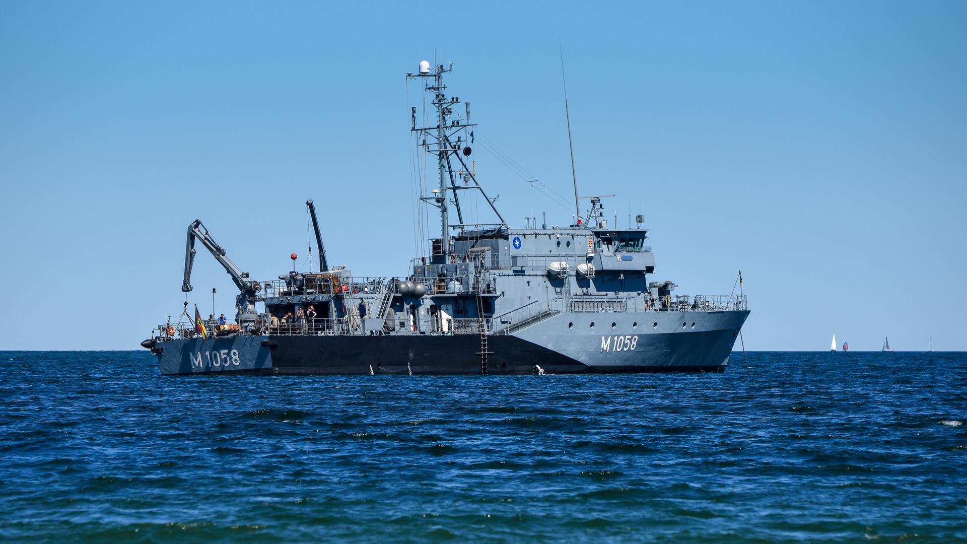 Das Foto zeigt das graue Minenjagdboot Fulda auf dem Meer. Auf dem Schiff befinden sich Antennen und ein Hebekran.