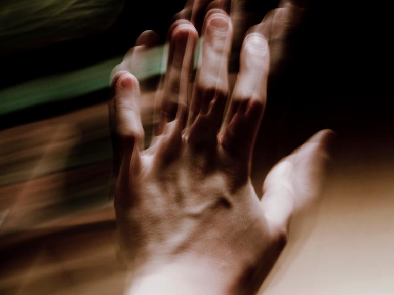 Verschwommenes Bild einer zitternden Hand.