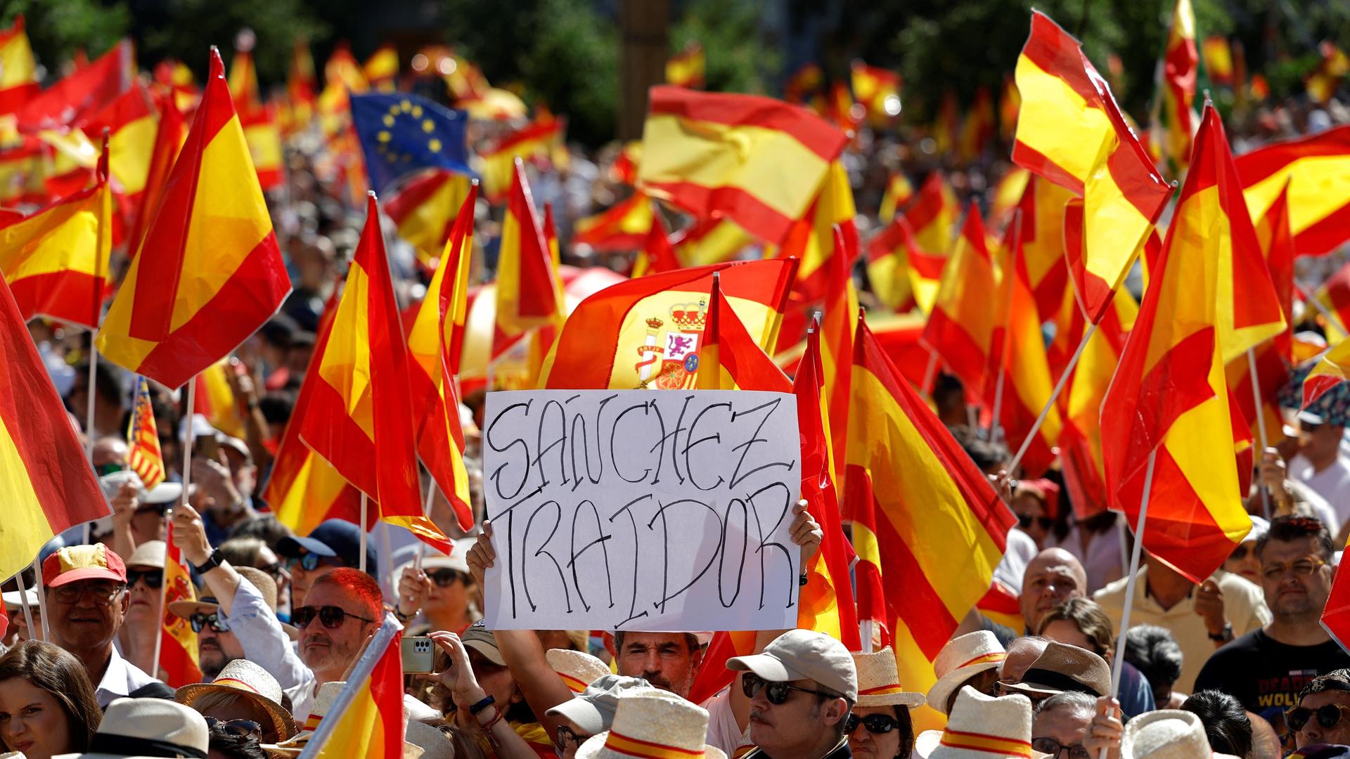 Das Bild zeigt Demonstranten in Madrid, die gegen die amtierende sozialistische Regierung von Pedro Sanchez protestieren. Auf einem Schild steht: Sanchez - Verräter. 