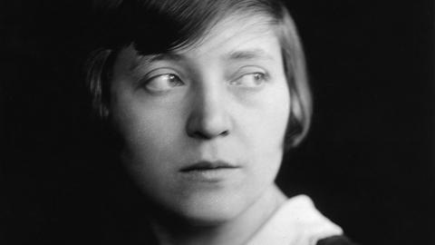 Schwarzweißes Porträt von Marieluise Fleißer im Jahr 1933. Sie trägt ihr kurzes Haar in einem tiefen Seitenscheitel und ein dunkles Kleid mit weißem Spitzenkragen.