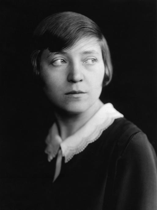 Schwarzweißes Porträt von Marieluise Fleißer im Jahr 1933. Sie trägt ihr kurzes Haar in einem tiefen Seitenscheitel und ein dunkles Kleid mit weißem Spitzenkragen.