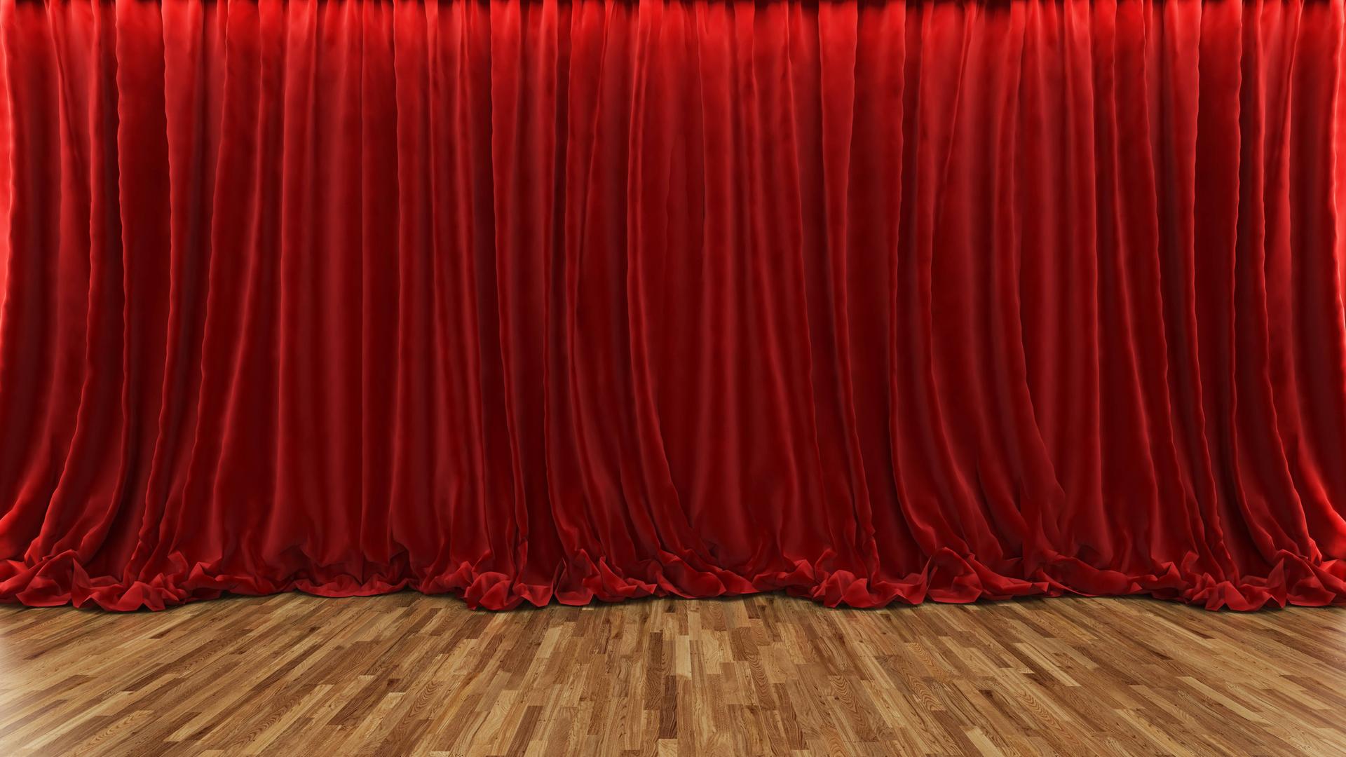 Ein geschlossener roter Samtvorhang in einem Theater.