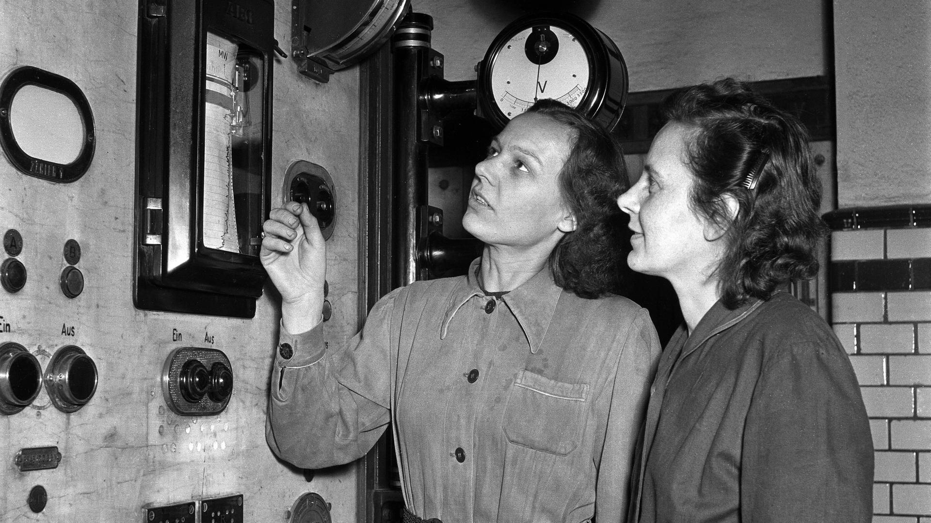 Historisches schwarz-weiß Foto: Zwei Arbeiterinnen bewachen Kontrollanzeigen in einem Kraftwerk in Osendorf/DDR 1953. 