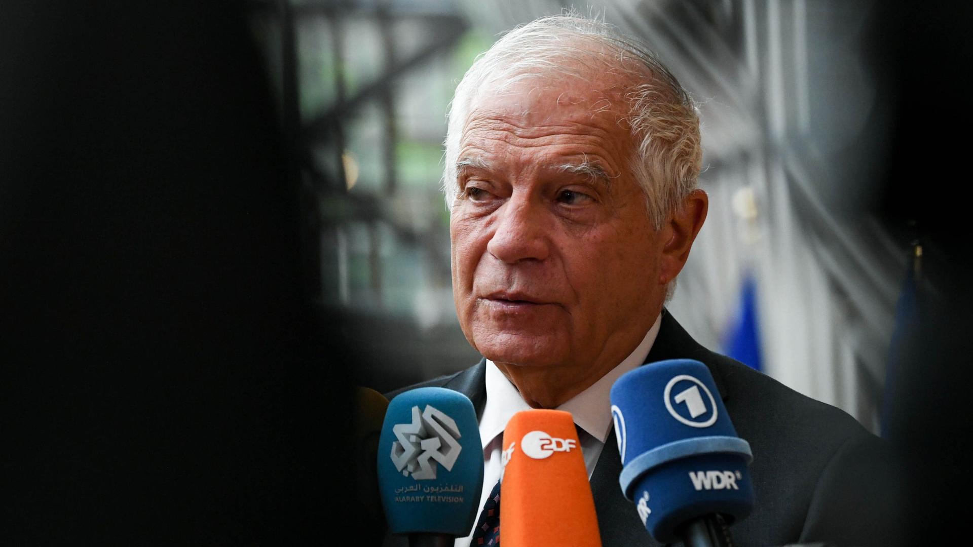 Borrell steht vor einigen Mikrofonen und sagt etwas. Das linke Bilddrittel ist schwarz. Borrell steht vor einigen Mikrofonen und sagt etwas. Das linke Bilddrittel ist schwarz.