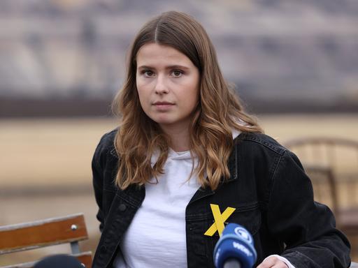 Klimaaktivistin Luisa Neubauer von Fridays for Future sitzt während eines Pressegesprächs im Dorf Lützerath am Rande des Braunkohle-Tagebaus Garzweiler II von RWE - an der Jacke trägt sie ein gelbes Kreuz, Symbol des Widerstands gegen die Braunkohle. 