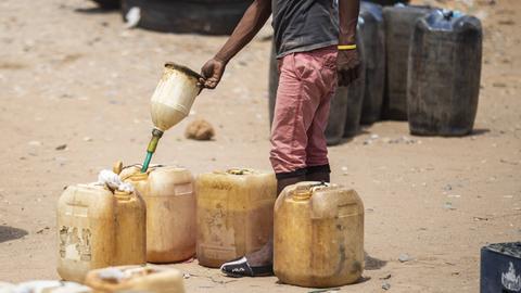 Kanister mit Benzin werden abgefüllt. Händler verkaufen Benzin an Reisende in Venezuela.