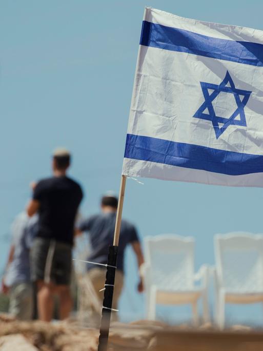 Jüdische Siedler hissen am 23. Mai 2025 israelische Flaggen auf palästinensischen Häusern im Dorf Bruqin im Norden des Westjordanlands, nachdem sie palästinensische Häuser beschlagnahmt und einen Teil ihres Eigentums zerstört hatten. 