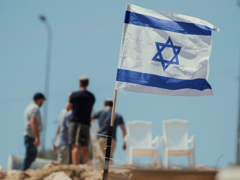 Jüdische Siedler hissen am 23. Mai 2025 israelische Flaggen auf palästinensischen Häusern im Dorf Bruqin im Norden des Westjordanlands, nachdem sie palästinensische Häuser beschlagnahmt und einen Teil ihres Eigentums zerstört hatten. 