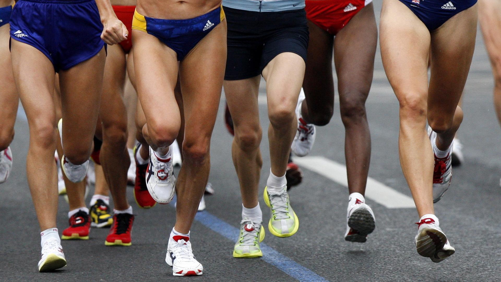 Die Beine von Läuferinnen und Läufern bei einem Marathon Die Beine von Läuferinnen und Läufern bei einem Marathon