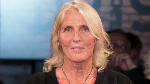 Heike Rath sitzt im Fernsehstudio. Sie hat schulterlanges blondes Haar und trägt eine Halskette mit einem silbernen Elefantenkopf.