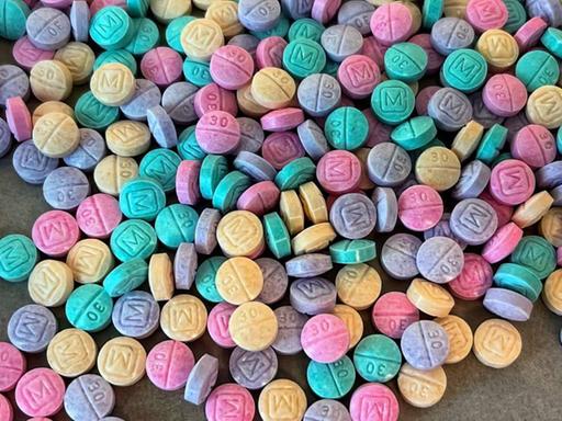 Fentanyl-Pillen in vielen bunten Farben liegen auf einem Tisch