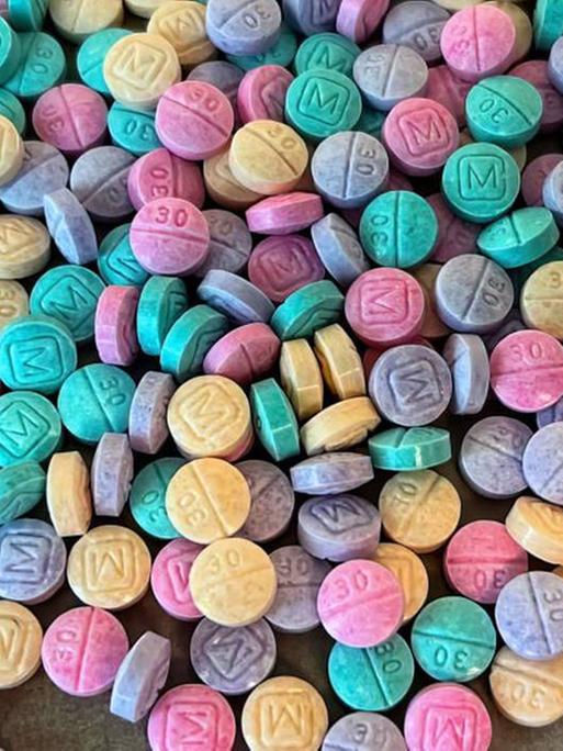Fentanyl-Pillen in vielen bunten Farben liegen auf einem Tisch