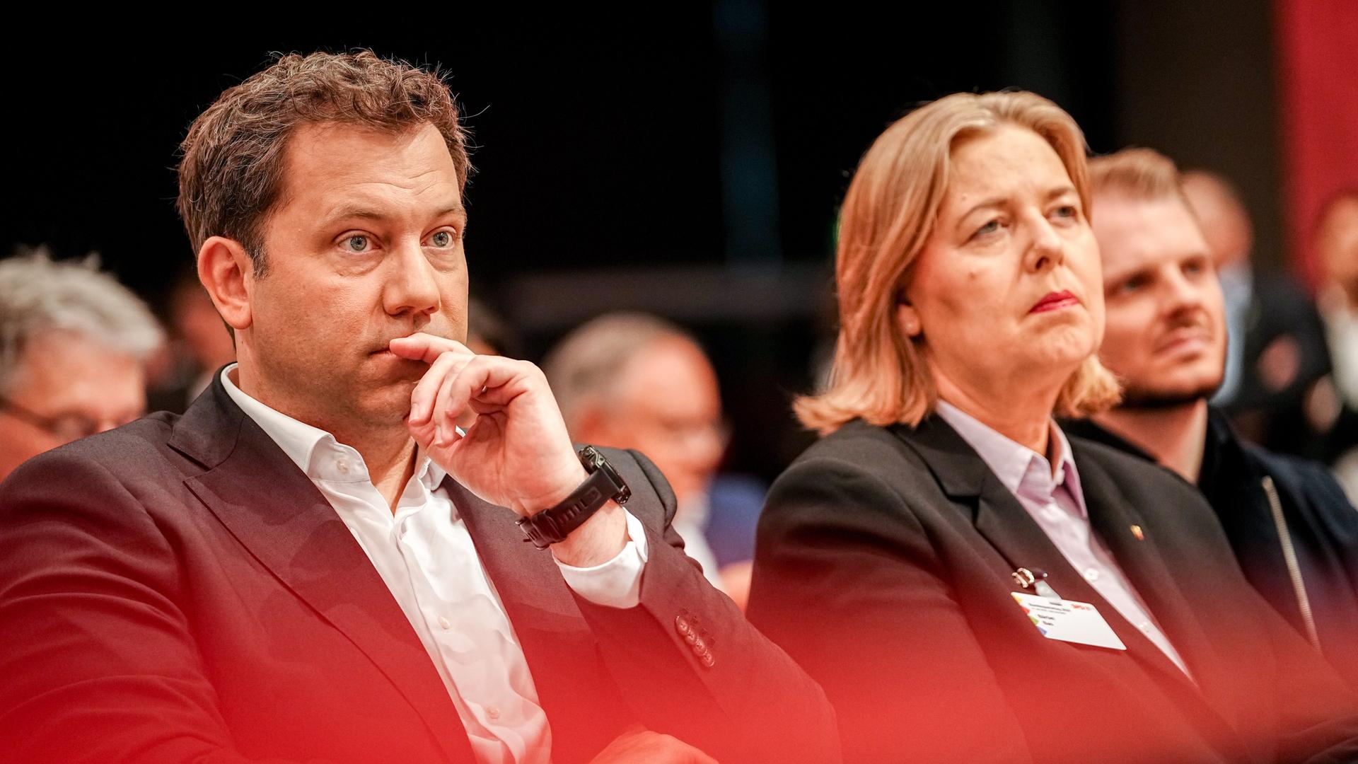 Lars Klingbeil und Bärbel Bas sitzen nebeneinander auf dem SPD-Parteitag 2025, beide mit ernsten Gesichtern und in formeller Kleidung. 