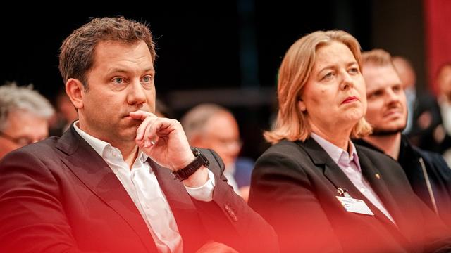 Lars Klingbeil und Bärbel Bas sitzen nebeneinander auf dem SPD-Parteitag 2025, beide mit ernsten Gesichtern und in formeller Kleidung. 
