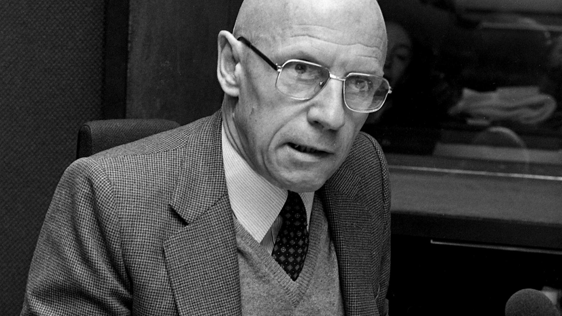 Schwarz-Weiß-Aufnahme von Michel Foucault, der in einem Radiostudio sitzt.