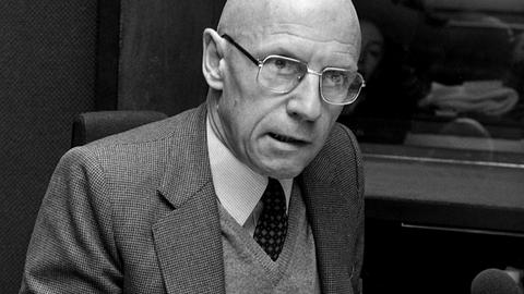 Schwarz-Weiß-Aufnahme von Michel Foucault, der in einem Radiostudio sitzt. Schwarz-Weiß-Aufnahme von Michel Foucault, der in einem Radiostudio sitzt.