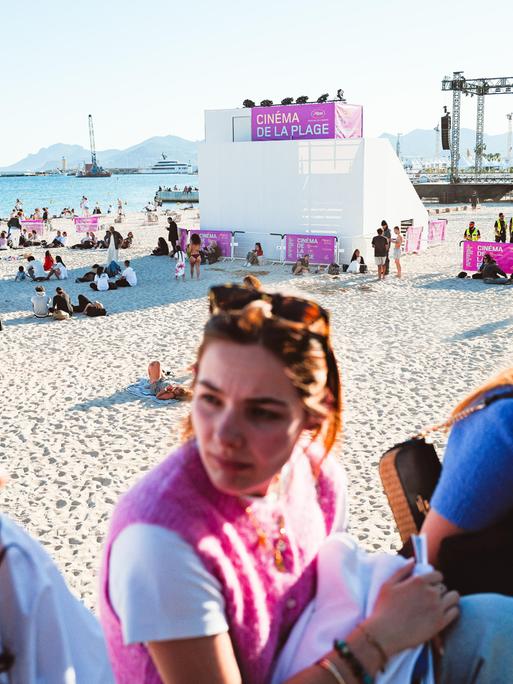 Junge Frauen unterhalten sich vor dem Mace Beach in Cannes, wo während der 79. Filmfestspiele von Cannes Strandkino-Vorführungen stattfinden