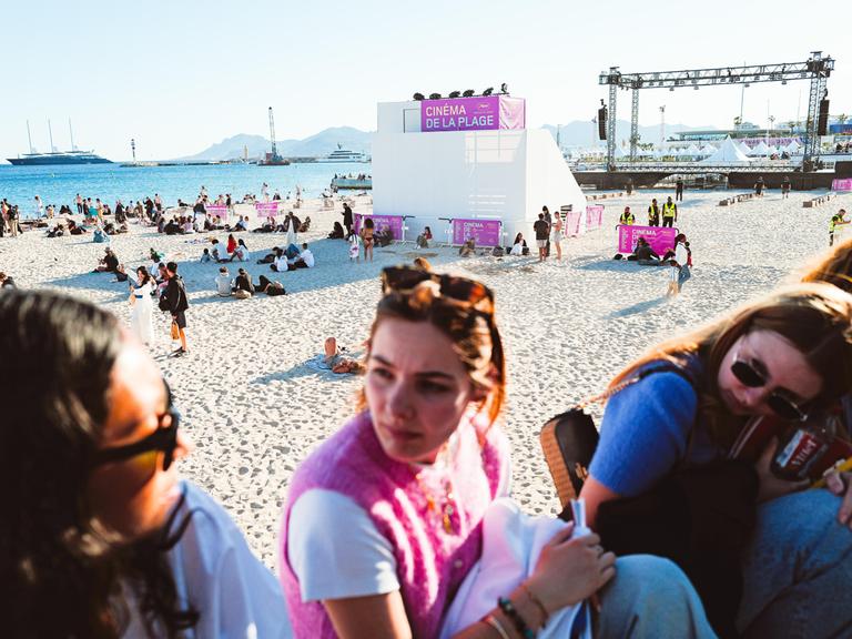 Junge Frauen unterhalten sich vor dem Mace Beach in Cannes, wo während der 79. Filmfestspiele von Cannes Strandkino-Vorführungen stattfinden