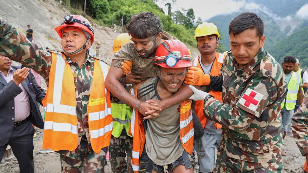 Ein Helfer trägt einen Arbeiter auf dem Rücken. Zwei nepalesische Soldaten helfen bei der Rettung. Ein Helfer trägt einen Arbeiter auf dem Rücken. Zwei nepalesische Soldaten helfen bei der Rettung.