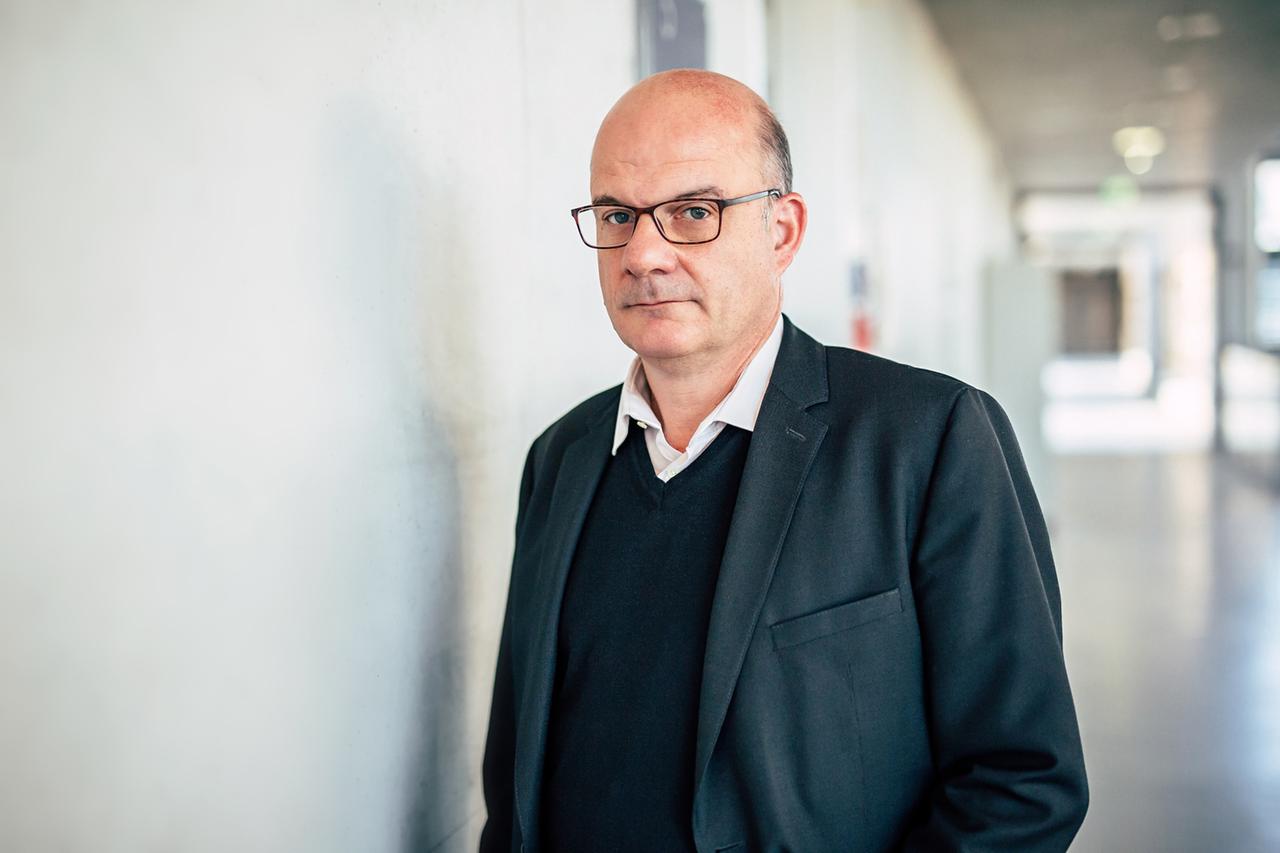 Prof. Dr. Thomas Kater steht an einer Wand geleht in einem Gang eines Bürogebäudes. Er ist Außerplanmäßiger Professor am Institut für Philosophie 
Geisteswissenschaftliches Zentrum der Universität Leipzig.